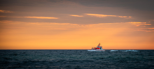 Emergency rescue boat infront of sunset
