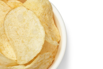 Delicious golden potato chips in a white bowl isolated on white background close-up.