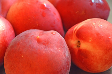 Bright juicy whole peach with water drops close-up