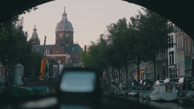 Being on a boat tour, through Amsterdam in the afternoon, Shot from St. Nicolaas Church