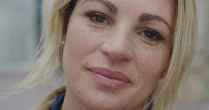 close up portrait beautiful young blonde woman smiling calm confident caucasian female with freckles friendly expression slow motion