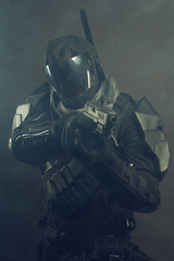 Cosplay futuristic solder with handgun. Dark background, hazy air.