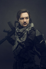 Cosplay futuristic solder. Portrait with machine gun. Dark background.