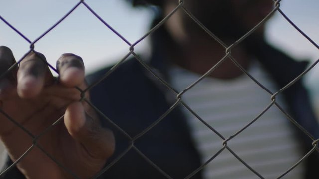 close up of african american man hand holding fence focus blur