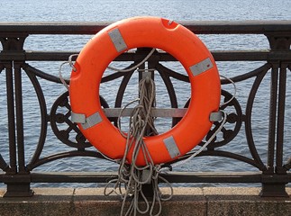 Orange lifebuoy on the embankment in Riga