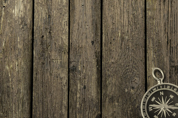 Compass on an old wooden background.