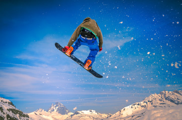 Snowboarder jumping in the blue sky