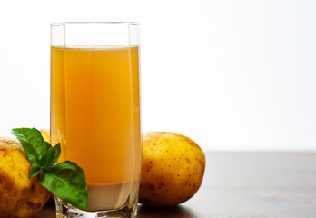 glass of potato juice on wooden table on white background with copy space.