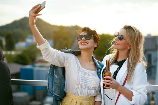 Attractive Women Making Photo On Mobile Phone