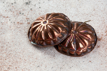 Vintage copper molds on a concrete background.