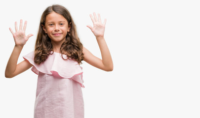 Brunette hispanic girl wearing pink dress showing and pointing up with fingers number ten while...