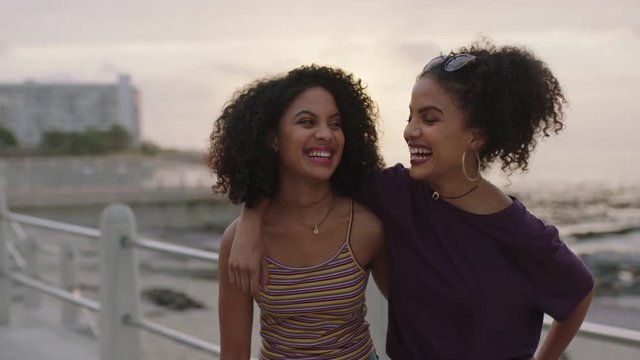 two loving hispanic sisters embrace laughing cheerful posing happy looking at camera