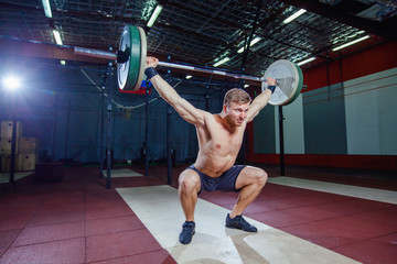 sporty man performing overhead squats with a heavy barbell at the gym complex crossfit overhead performance athlete active lifestyle weightlifting bodybuilder. Cross style fit, deadlift