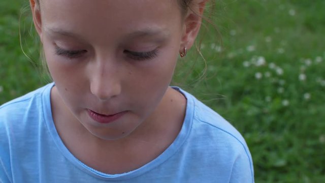 Young girl in blue t-shirt eat frozen juce icecream. Top-down shot closeup