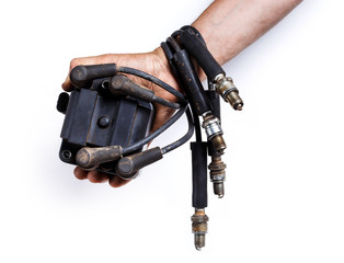 Hand holding car ignition parts. High-voltage wires, spark plugs and ignition coil for gasoline...