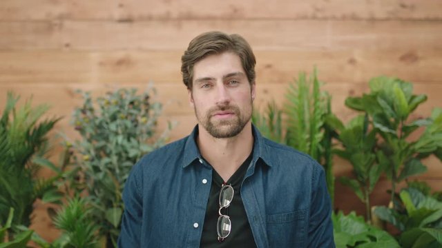 attractive young man portrait of handsome caucasian guy arms crossed looking pensive serious at camera 
