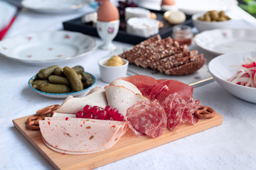 Frükstück Buffet Tisch mit Wurst Schinken Platte Teller und Brot, Essiggurken, Eier und Käse