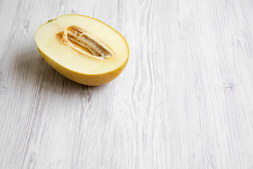 Half of melon on white wooden surface, copy space.
