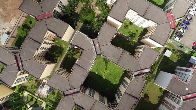 Aerial: bird's eye of squared shaped city buildings with parking lot 3
