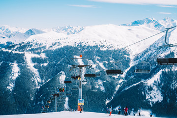 Ski lefts and cable cars in the Alps winter resort. People going up for skiing and snowboarding....