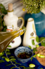 the olive oil in the cup. Branch of an olive tree with fresh olives. Green olives. In the garden. On a wooden board. Proper nutrition.Italian ceramics. jug for oil. Italian classics. Olives of Italy