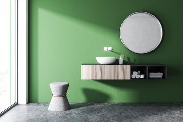 Green bathroom with a round sink, mirror
