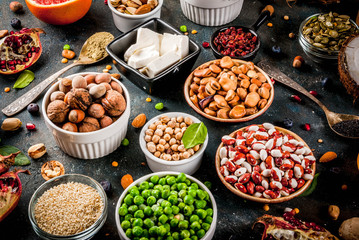 Set of organic healthy diet food, superfoods - beans, legumes, nuts, seeds, greens, fruit and vegetables. Dark blue background copy space