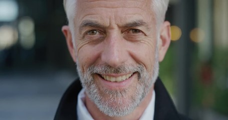 close up portrait successful mature businessman smiling enjoying successful urban lifestyle happy senior professional slow motion