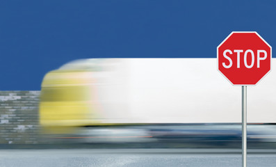 Red stop road sign, motion blurred truck vehicle traffic background, give way regulatory warning...