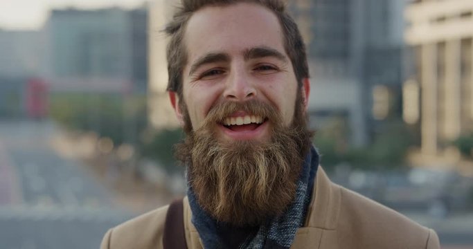 close up portrait professional young hipster man laughing enjoying successful urban lifestyle happy bearded entrepreneur in city at sunset slow motion