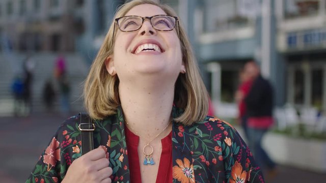 portrait of trendy blonde business woman laughing happy wearing glasses floral shirt enjoying urban travel