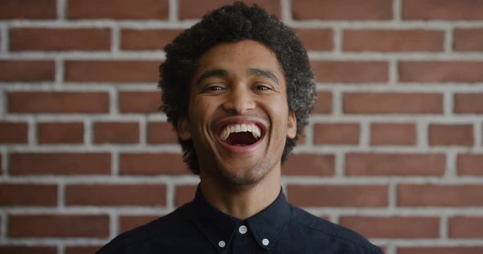 portrait happy young mixed race man laughing cheerful independent male enjoying lifestyle success afro hairstyle slow motion