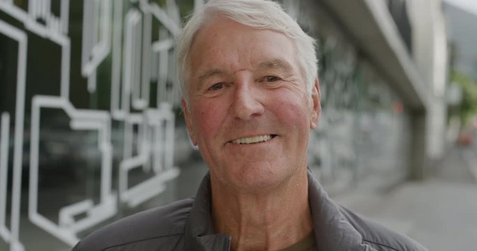 portrait of cheerful senior caucasian man smiling happy looking at camera enjoying relaxed retirement confident satisfaction city street background
