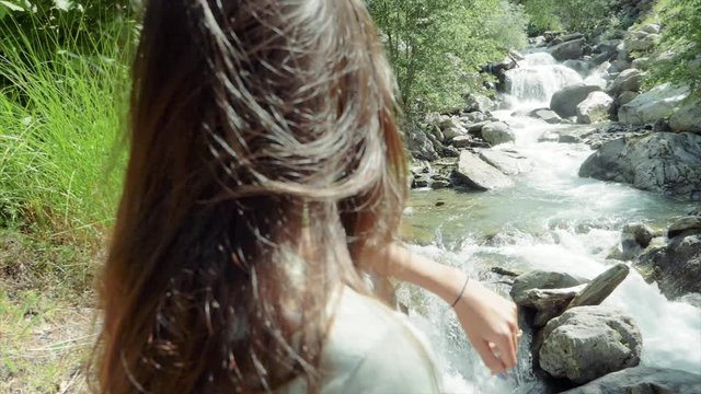 SLOW MOTION Standing behind a woman looking out at a waterfall in Auron, France.