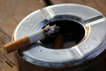 smoked cigarette in stainless ashtray
