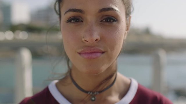 close up portrait of young beautiful hispanic woman looking pensive thoughtful on sunny beachfront background