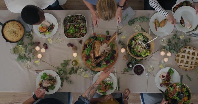 top view young diverse friends enjoying thanksgiving lunch together bonding over delicious homemade meal healthy holiday feast 