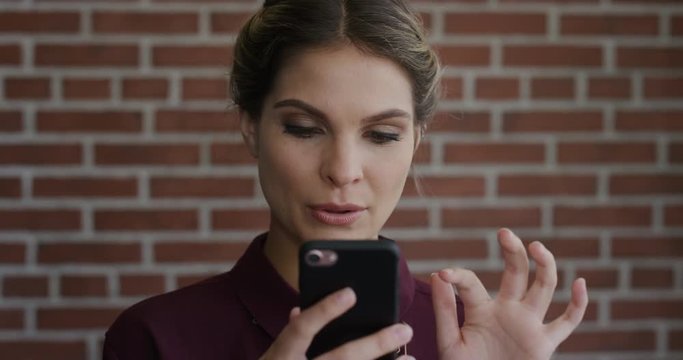 portrait beautiful young woman using smartphone browsing online looking pensive enjoying mobile internet connection technology slow motion