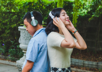 Sister and brother are listening to music in the garden