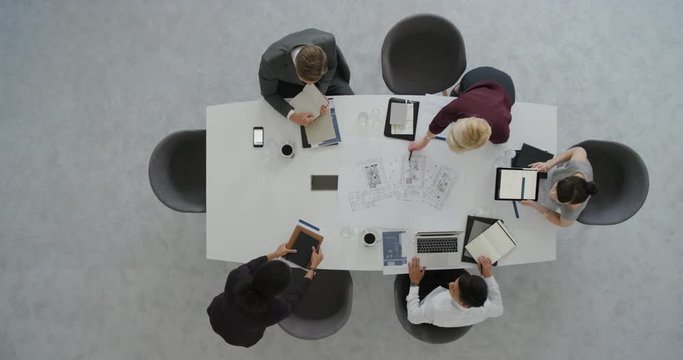 professional business people architects looking at building floor plan sharing ideas developing creative ideas for corporate architecture project in boardroom meeting top view