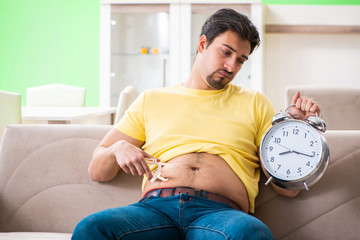 Man measuring body fat with calipers in time management concept 