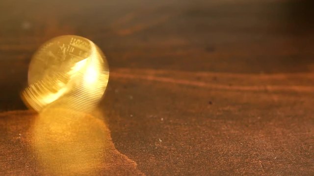 Spinning a golden bitcoin on a table.