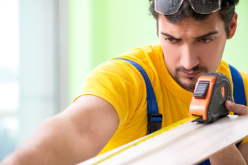 Professional contractor laying flooring at home