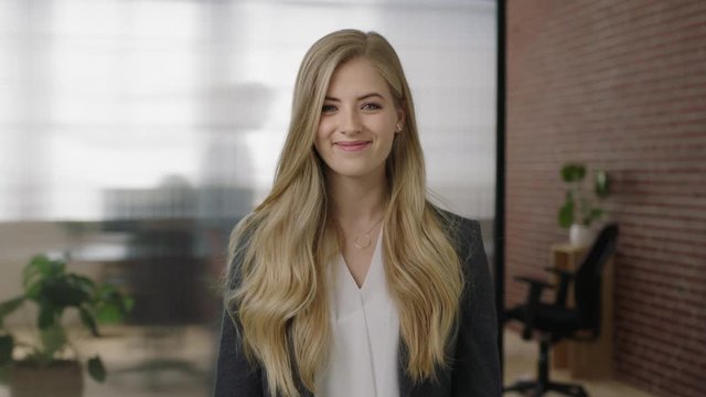 portrait of attractive young blonde woman executive smiling cheerful arms crossed enjoying start up business opportunity confident independent female