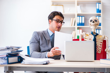 Businessman working with skeleton in office
