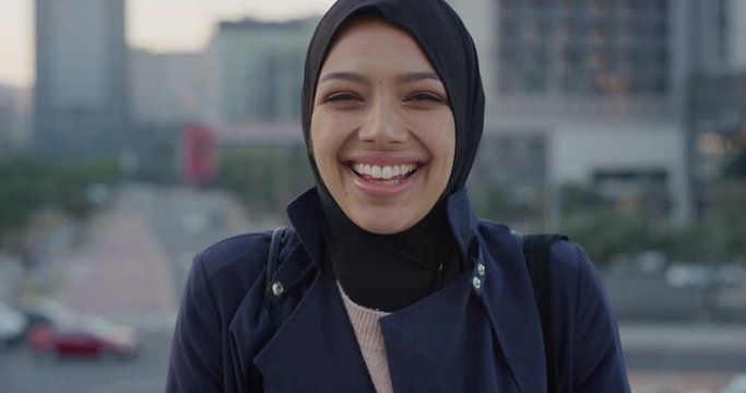 portrait happy young muslim business woman laughing enjoying professional urban lifestyle in busy city independent female wearing hijab headscarf slow motion