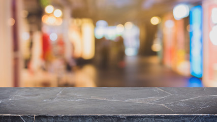 Empty black marble stone table top on blurred with bokeh shopping mall background - can be used for display or montage your products