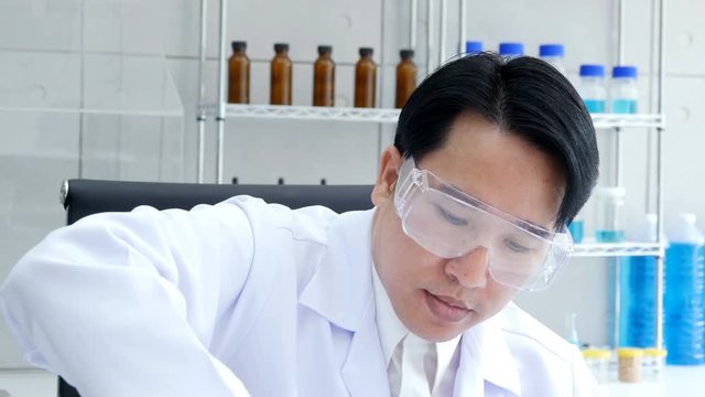 Asia Male scientist holding sample experiment in hand at laboratory. People with science concept. 4K Resolution