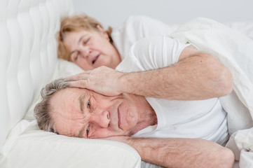 Fototapeta na wymiar senior man who can not sleep because his wife snores