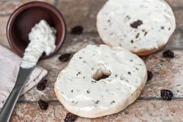 Fototapeta na wymiar Toasted Bagel with Onion and Vegetable Cream Cheese Plus Dehydrated Cherries On Stonewear Platter